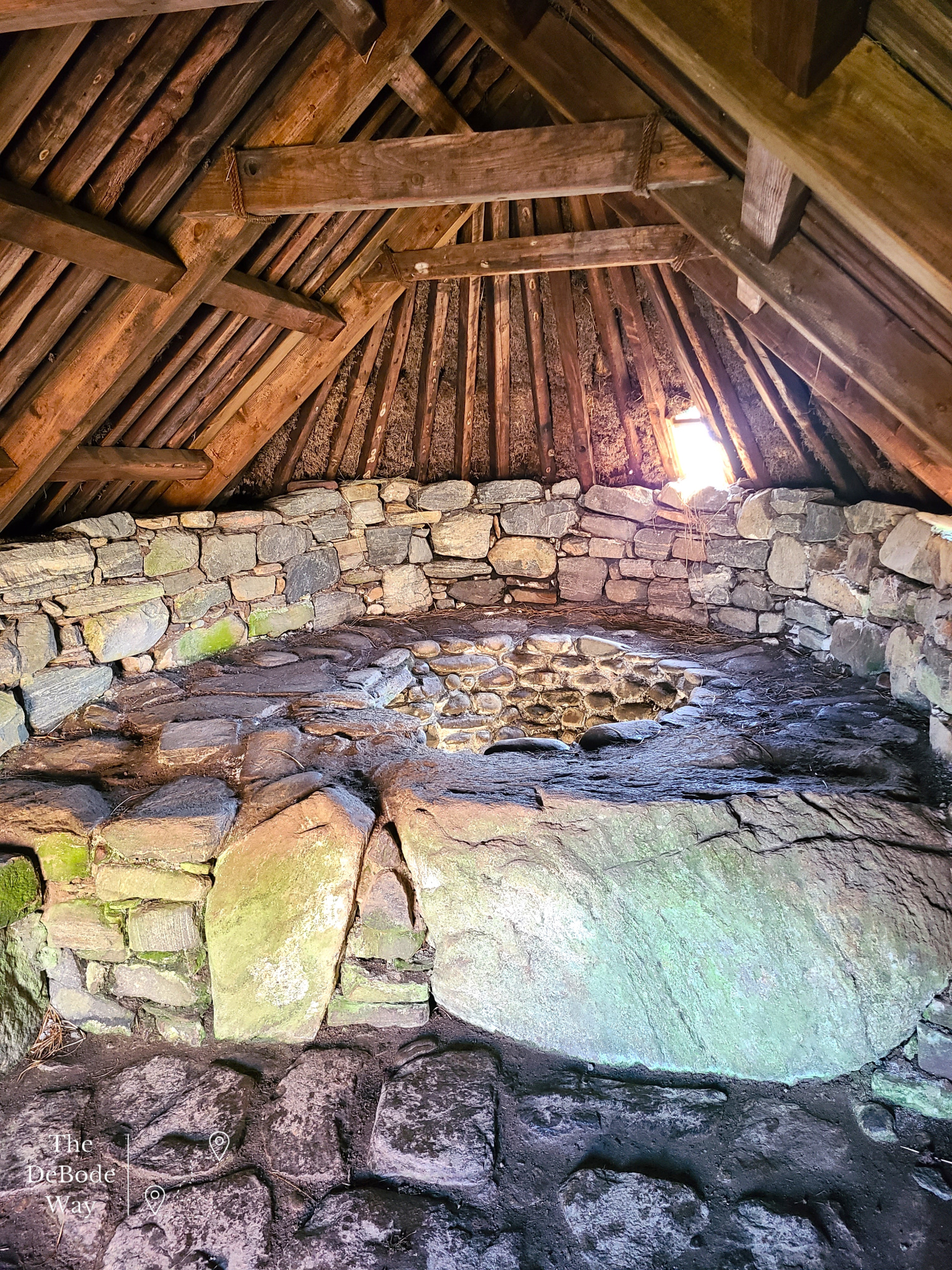Inside of stone floored kiln used to dry grain, covered by a wood and thatch roof