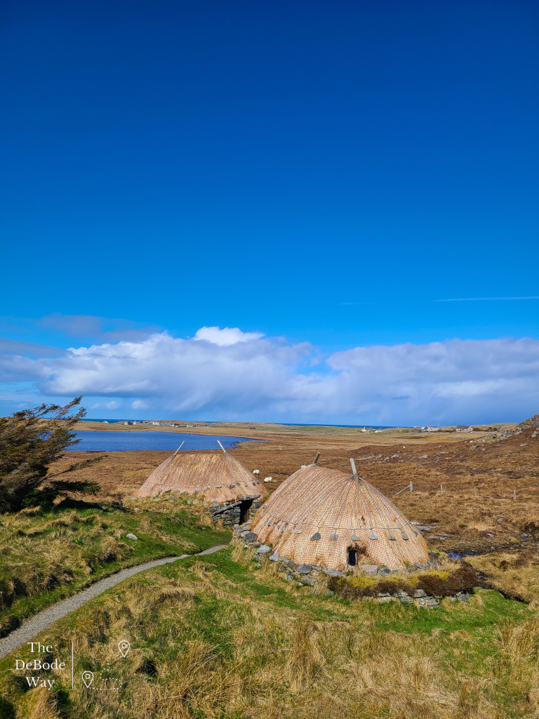 Stone age mill and kiln built with stacked stones and thatch roof close to low lying bay