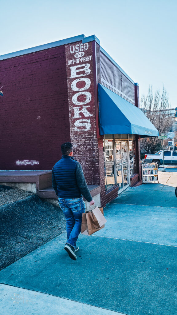 Jason walking with bags to book shop