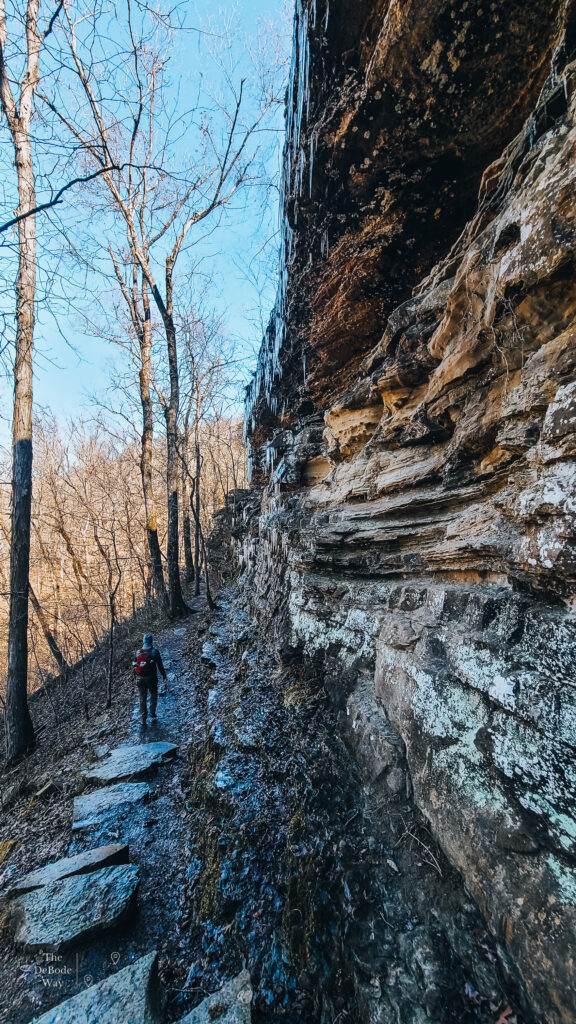 Cliff edge with icicles and hiker