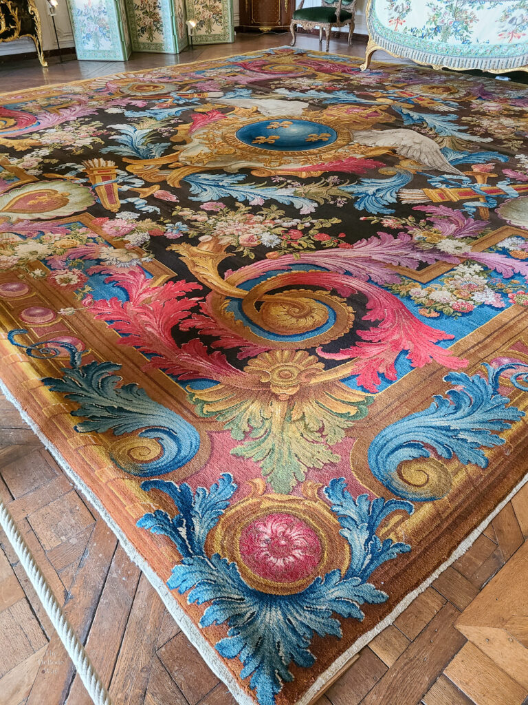 colorful scrolling rug in a bedroom at the Palace of Versailles