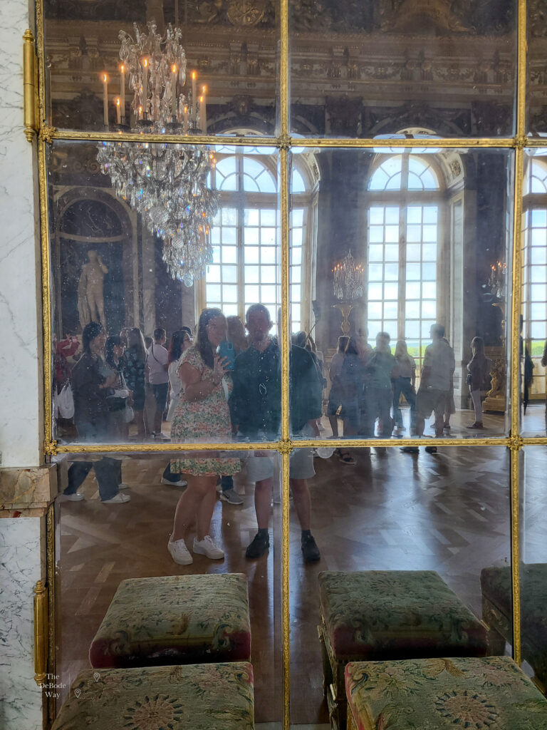 Tasha and Jason's reflection in a mirror in the Hall of Mirrors at the Palace of Versailles