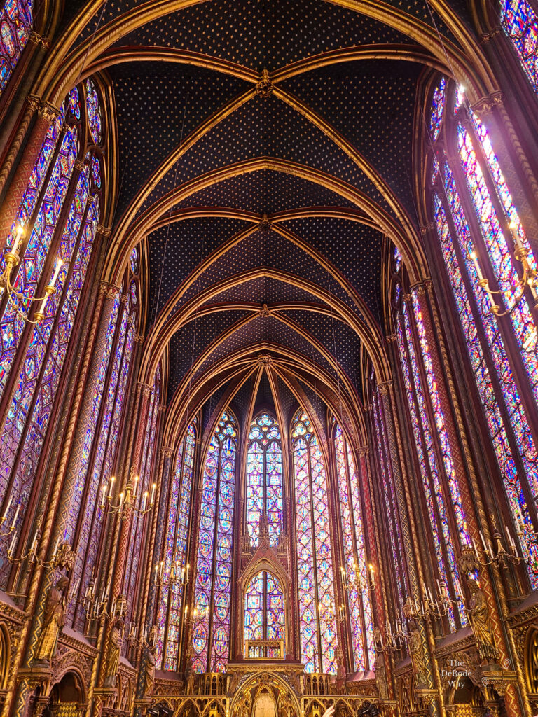 Colorful tall stained glass windows and blue ceiling with gold stars at Saint-Chappelle Paris