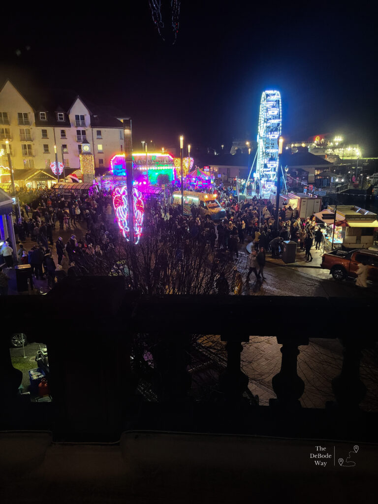 Crowds of people and Christmas lights at Oban Winter Festival in the town square