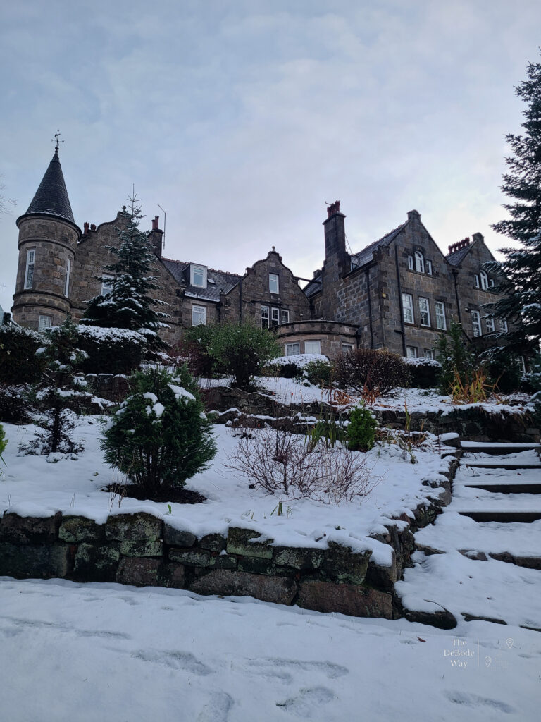 The stone front facade of Dowans Hotel in the snow.