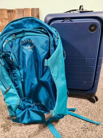 My trusty teal Osprey backpack and my new, roughed up, blue Monos luggage to pack for with our international travel packing list